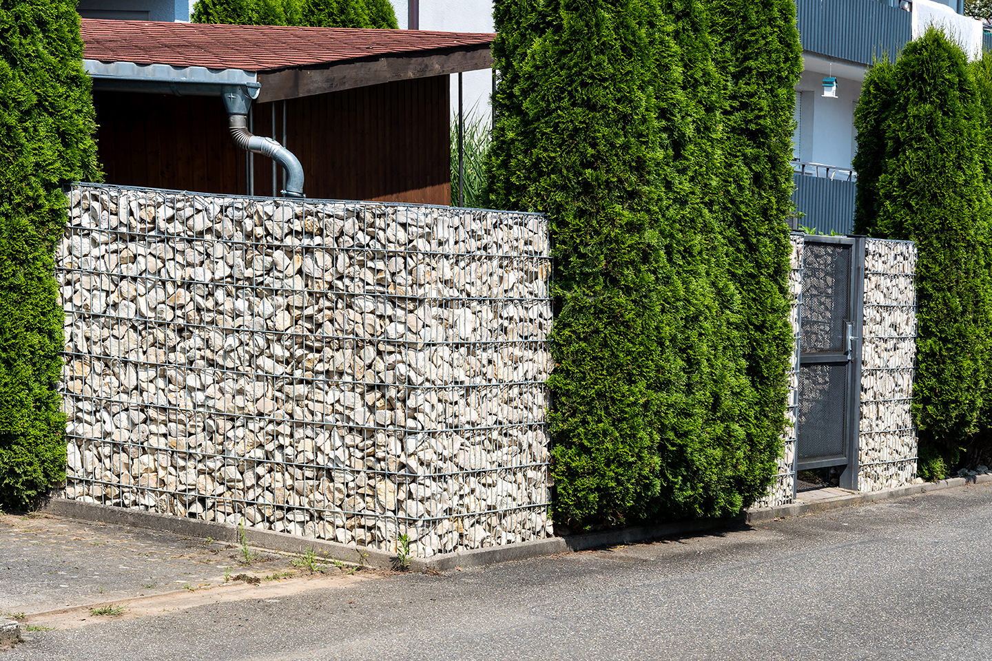 Gabionenzaun vor einem Wohnhaus. Eine Gabione (auch Steinkorb, Schüttkorb, Mauersteinkorb oder Drahtschotterkasten genannt), ist ein mit Steinen gefüllter Drahtkorb